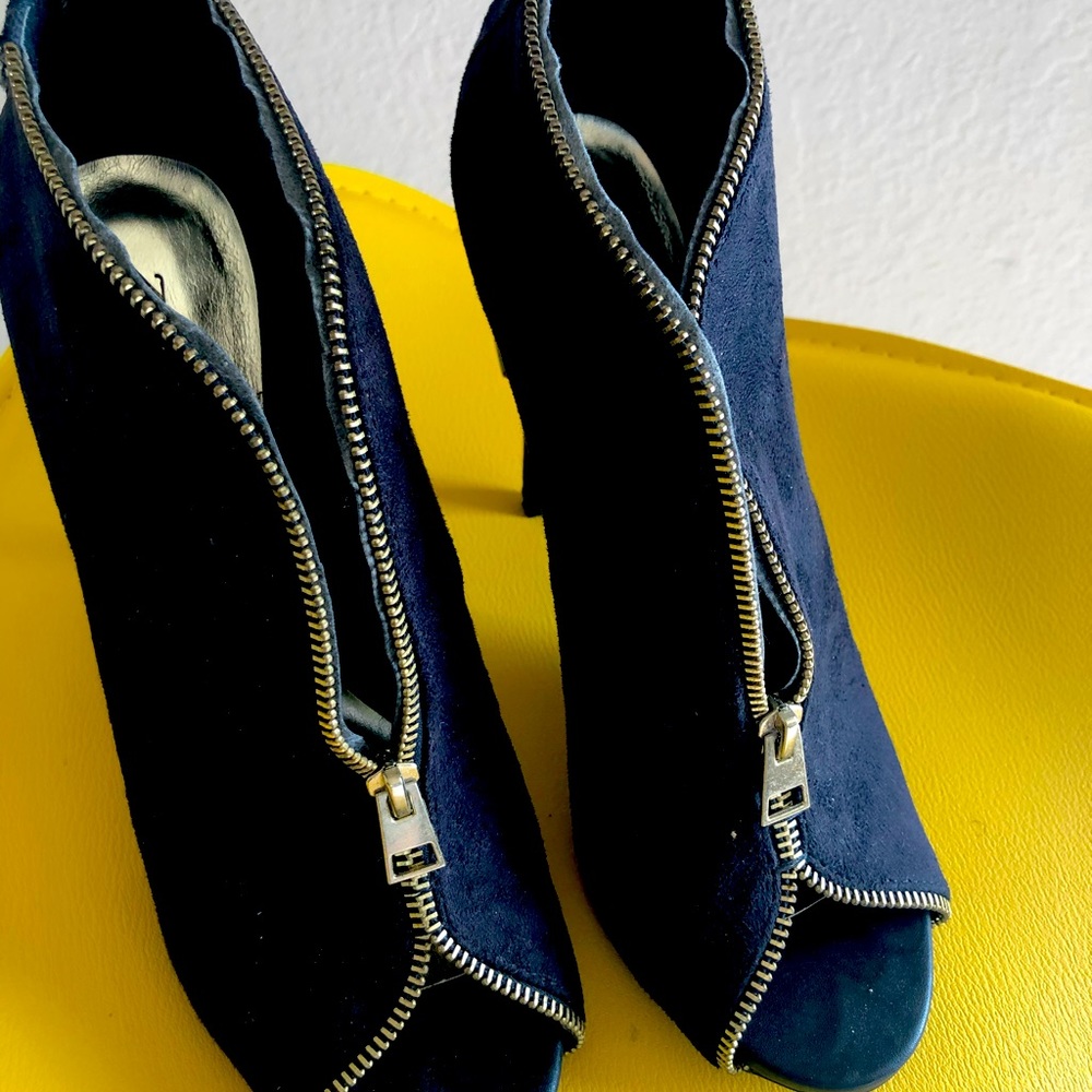 Black heel, accented with gold zippers. Worn once.